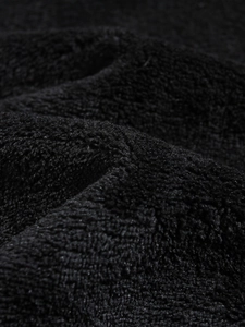 Close-up of soft black coral fleece fabric showing the thick plush texture of the hoodie
