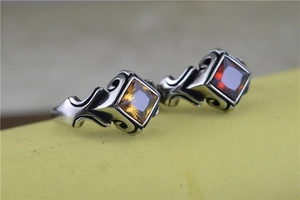 Detailed view of Gothic rings with amber and burgundy square gems in ornate steel settings