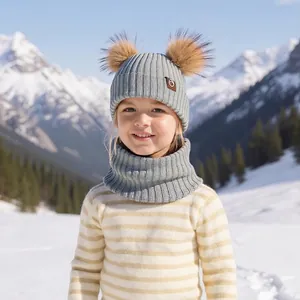 Kids winter knit hat and neck warmer set in light grey with brown faux fur pom poms