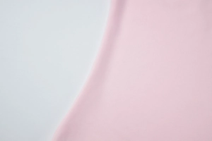 Close-up detail of smooth pink fabric texture for irregular sleeveless summer vest