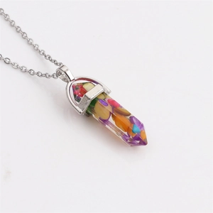 Close-up of hexagonal bullet pendant with multicolored stones on silver chain necklace