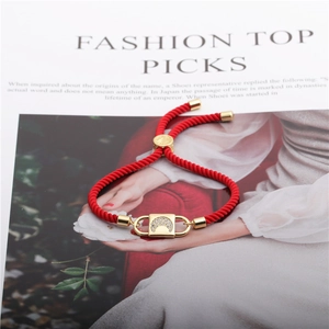Detail of red braided bracelet with gold moon star charm and adjustable sliding bead