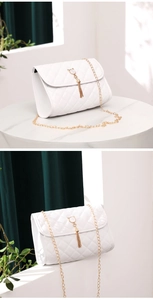 Detail of white quilted crossbody bag featuring golden cat pendant and elegant tassel