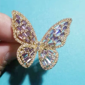 Detailed close-up of a golden butterfly ring with purple gems and sparkling crystals