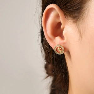 Close-up of gold-plated bird earring with micro-paved cubic zirconia on the ear