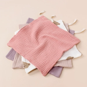 Detailed texture of 4-pack muslin cotton baby face towels with bear print and hanging loops