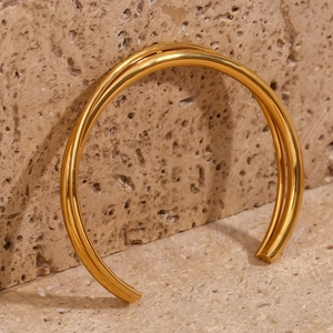 Detail shot of a double-layered cross-open bangle in 18K gold plated stainless steel