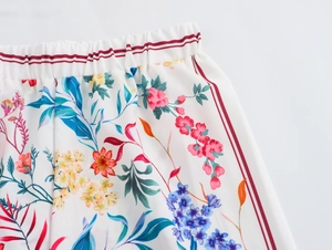Detail view of elastic waist with red stripes on floral print bohemian trousers