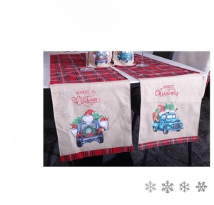 Détail d'un chemin de table de Noël avec motif à carreaux rouges et camion bleu sur lin
