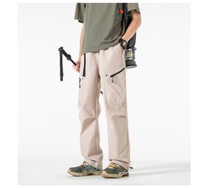 Detail of cargo pants with adjustable drawstring hems and side zipper utility pockets