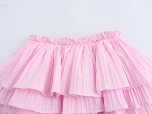 Detailed close-up of pink layered ruffle skirt featuring elastic pleated waistband
