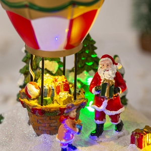 Macro view of Santa Claus and hot air balloon Christmas ornament with glowing LED lights