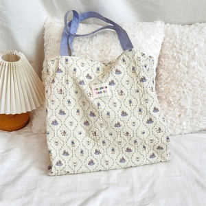 Close-up of beige canvas bag with blue Peter Rabbit pattern and fabric handles