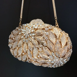 Close-up of golden leaf evening clutch bag with intricate rhinestones and metal chain