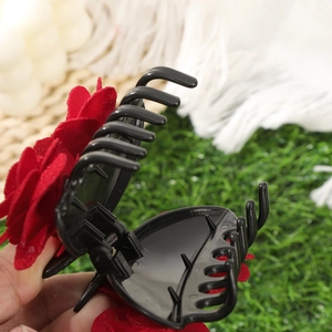 Detail showing the internal spring and teeth mechanism of the red rose hair claw clip