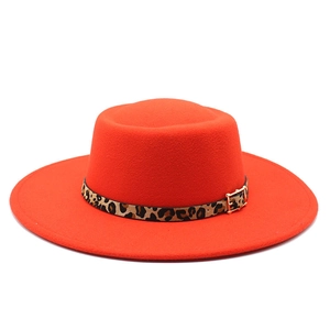 Détail d'un chapeau en laine orange avec bandeau léopard et boucle dorée