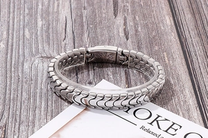 Nahaufnahme eines silbernen Gliederkettenarmbands aus Edelstahl auf Holzoberfläche