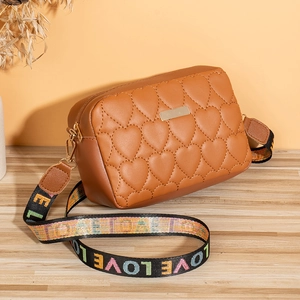 Detailed view of brown quilted heart crossbody bag with colorful LOVE patterned strap