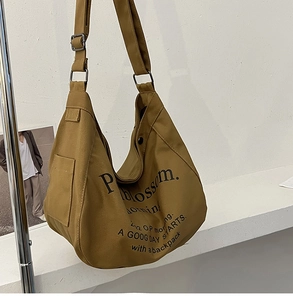 Vue détaillée du sac hobo en toile jaune moutarde avec impression de lettres Blossom