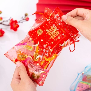 Macro view of a red organza drawstring bag with gold star and moon foil patterns