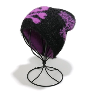 Detail showing plush mohair texture and purple skull pattern on the black knit beanie