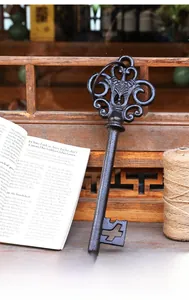 Detail of vintage cast iron decorative key with scrollwork on rustic wooden background