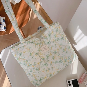Detailed view of quilted floral tote bag showing fabric texture and woven label