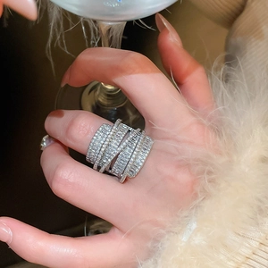 Close-up of sparkling wide multilayer silver ring with cubic zirconia stones on model hand
