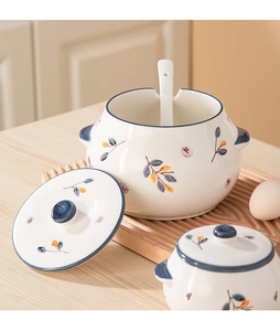 Detail of white ceramic seasoning jar with hand-painted floral patterns and serving spoon