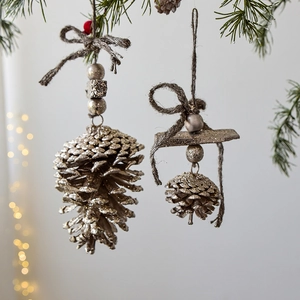 Christmas pinecone ornaments with silver glitter finish hanging on a festive tree branch