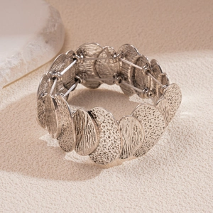 Detailed view of silver elastic bracelet featuring a unique hammered metallic texture