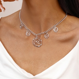 Detailed view of silver swirl pendant necklace showing artistic metallic spiral charms