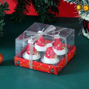 Detail of four red Santa hat candles in clear gift box with silver ribbon for Christmas