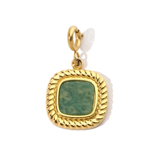 Macro view of a vintage gold square pendant with a green gemstone and twisted border