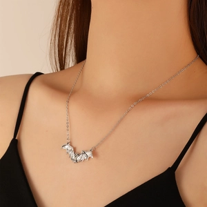 Close-up of a silver bat pendant necklace worn by a model for a gothic punk look