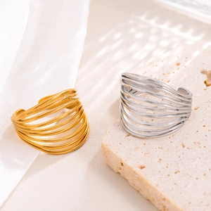 18k gold and silver multilayered stainless steel rings on a minimalist stone base