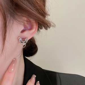 Close-up of Sphinx cat stud earring with rhinestones and metal chain on model