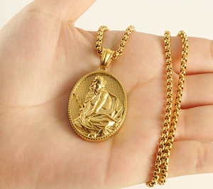 Détail d'un pendentif vintage 18k en relief 3D sur une chaîne à mailles rondes