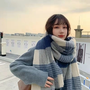 Close-up of blue, grey and beige plaid scarf texture in warm cashmere-like wool blend