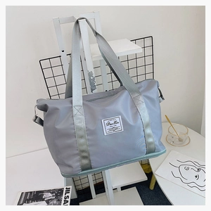 Detailansicht der grauen Oxford-Reisetasche mit robusten Riemen und Leder-Logo-Patch