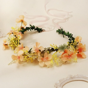 Couronne de fleurs pour mariée avec fleurs oranges, bourgeons jaunes et rubans roses en soie