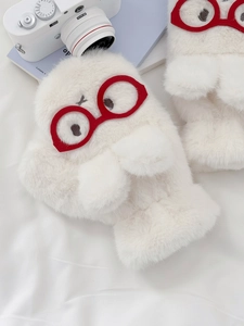 Detailed view of white plush mittens with red glasses embroidery and furry texture