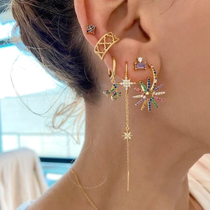 Detailed view of gold butterfly earrings set with rainbow cubic zirconia on ear