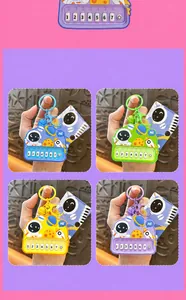 Close-up of four colorful astronaut-themed mini piano keychains held by hands for scale.