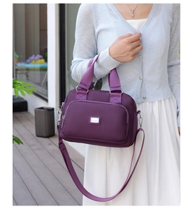 Outdoor shot of a purple large capacity nylon crossbody bag worn by a model