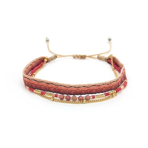 Macro detail of multi-layered bohemian beaded bracelet with woven strap and gold chain