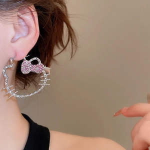 Close-up of diamond-encrusted Hello Kitty cat hoop earring with pink bow details