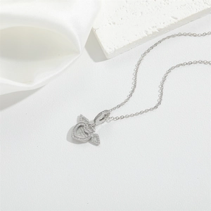 Elegant silver heart necklace with angel wings and zircon stones on white silk background