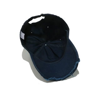 Detailed view of frayed edges and stitching on a distressed cotton baseball cap