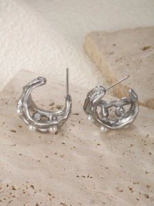 Detail of silver lava textured earrings with organic fluid design and white pearls